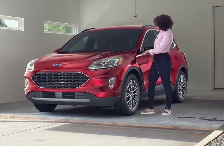 Woman charging a red 2021 Ford Escape Plug-In Hybrid