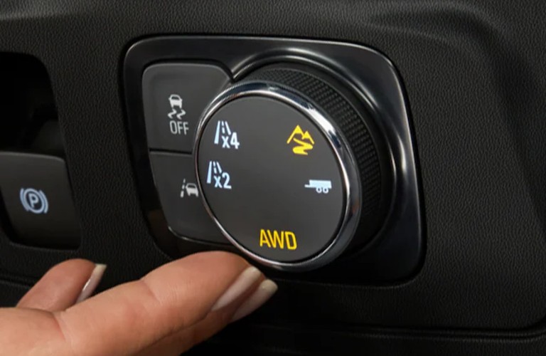 Person turning the drive mode dial inside the 2021 Chevrolet Traverse