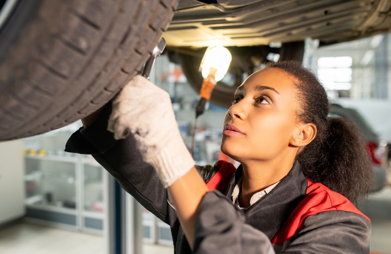 Female mechanic working on a car