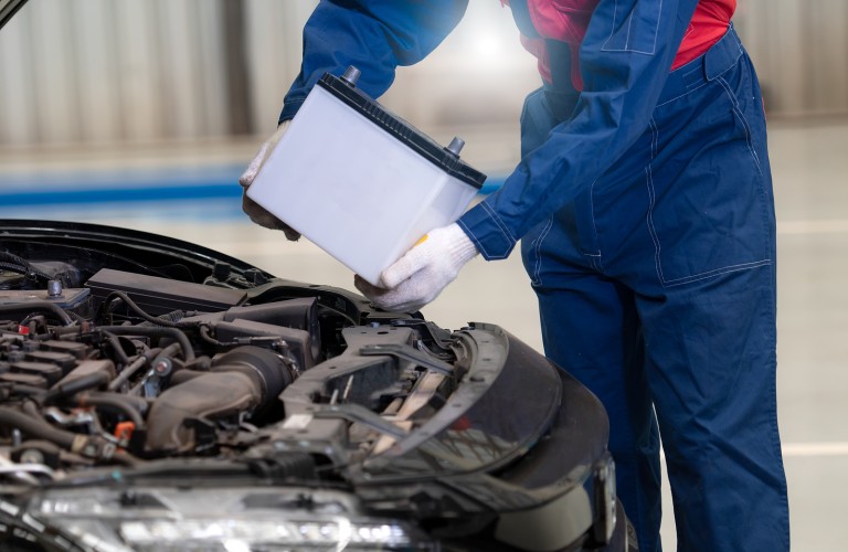 Mechanic replacing a car battery