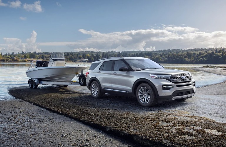 Front passenger angle of a silver 2021 Ford Explorer hitched to a boat
