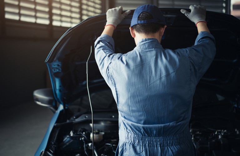 Mechanic opening the hood of a car