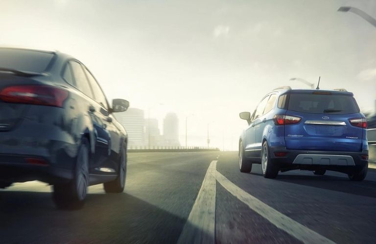 A car driving next to a blue 2021 Ford EcoSport