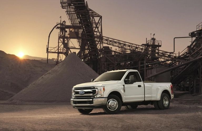 A white 2022 Ford F-350 parked at a construction site during sunset