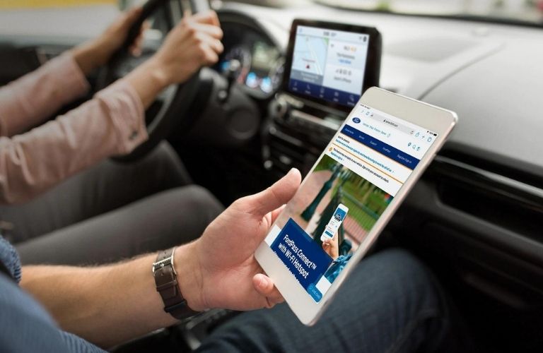 People holding the device using a Ford app in the 2021 Ford EcoSport.