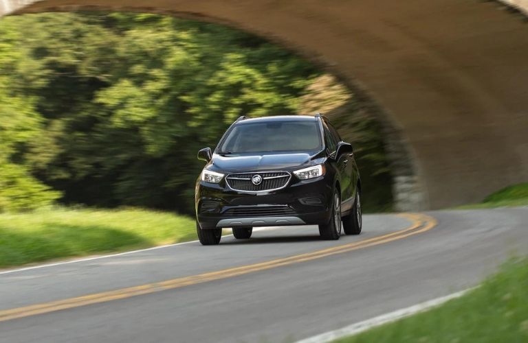 The black 2021 Buick Encore driving on the road.