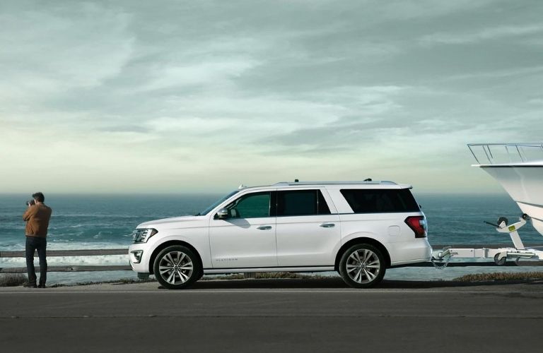 A white 2021 Ford Expedition at the port with a man standing in front of it.