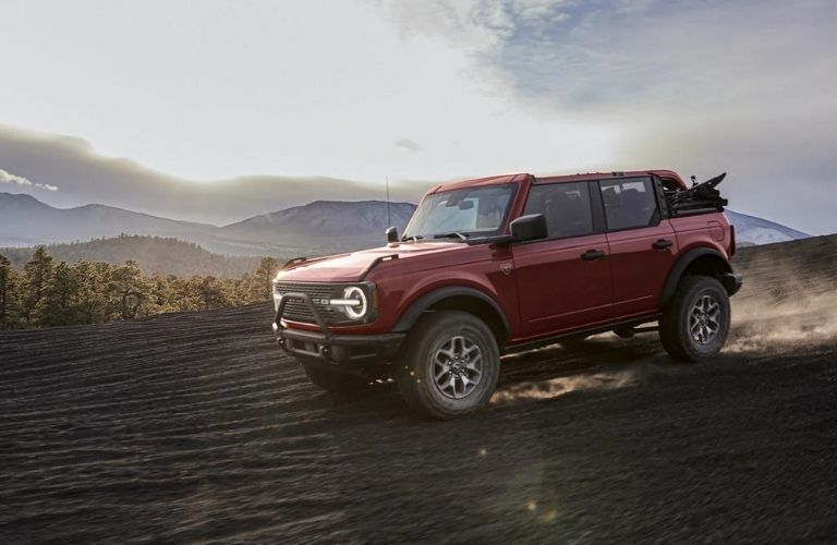 A red 2021 Ford Bronco driving downhill.