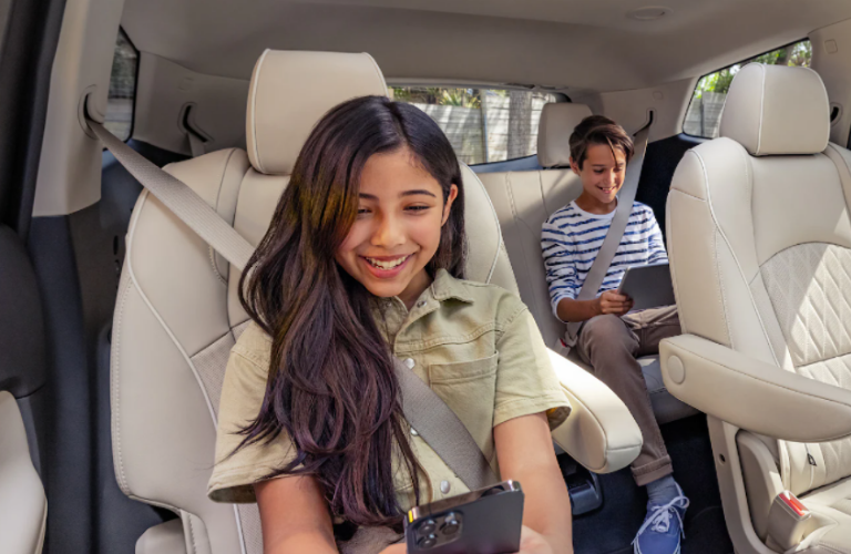 Kids looking at the phone while sitting in the 2022 Buick Enclave