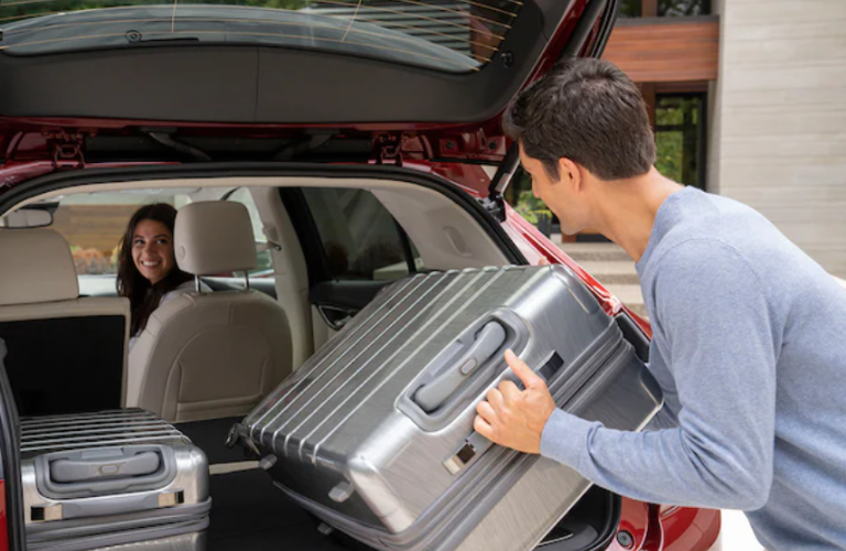 A man keeping luggage inside the 2022 Buick Envision.