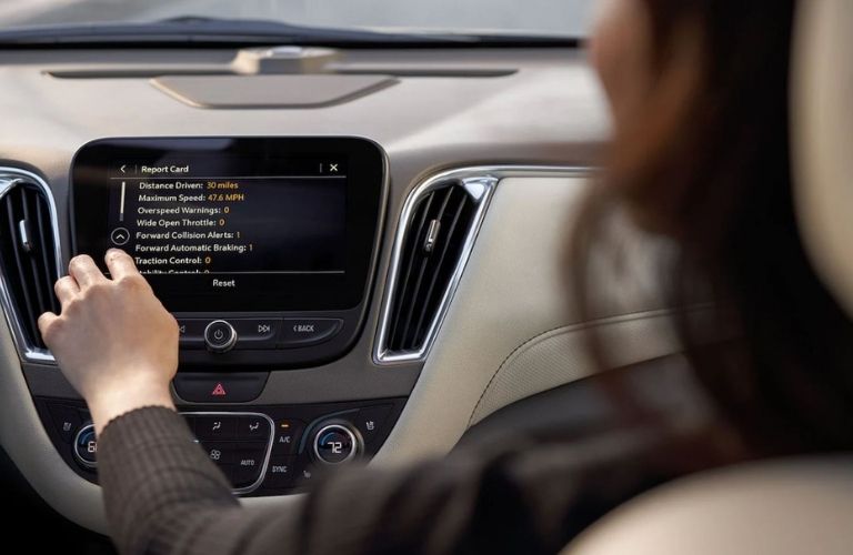 Image showing a woman scrolling through the Teen Driver menu on the infotainment screen in her car