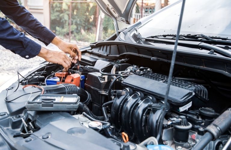 A mechanic fixing the engine under the hood