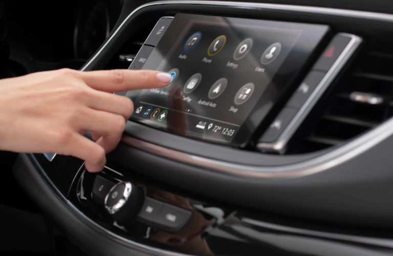 A person operating the 2023 Buick Enclave touchscreen 