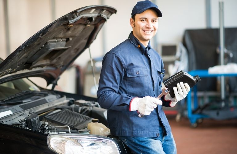 Mechanic standing in front of a vehicle