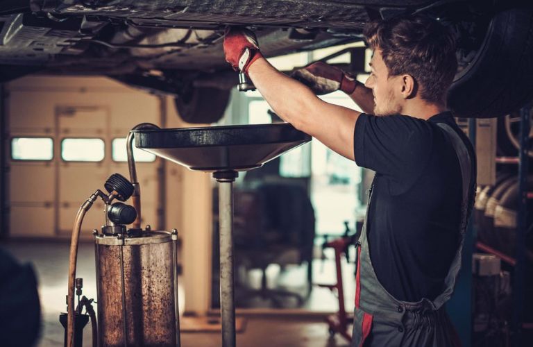 Mechanic changing vehicle oil