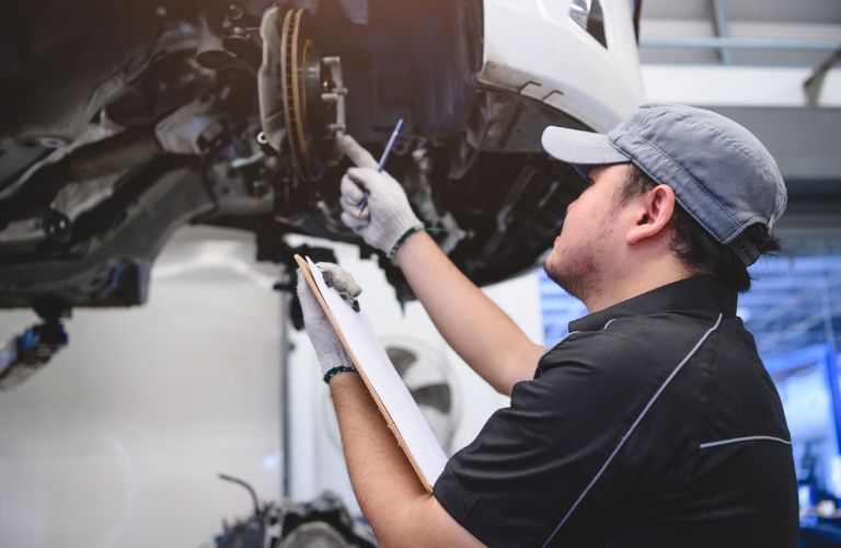 Technician checking a vehicle's brake