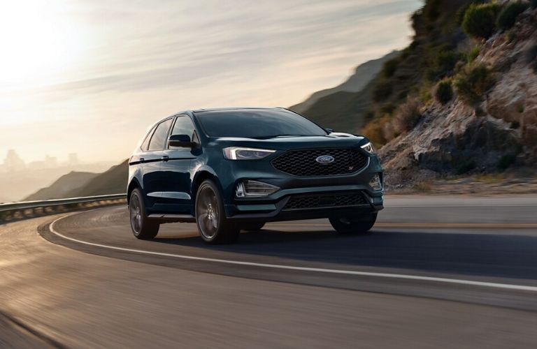 One green color 2024 Ford Edge is running on the road.