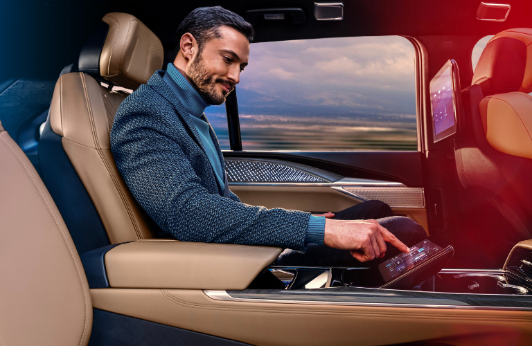 A man using the 2025 Cadillac ESCALADE IQ touchscreen 