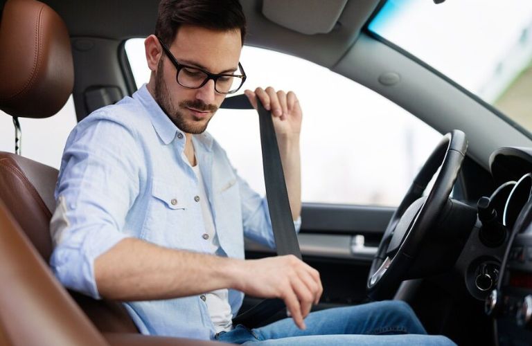 a man putting on seat belt