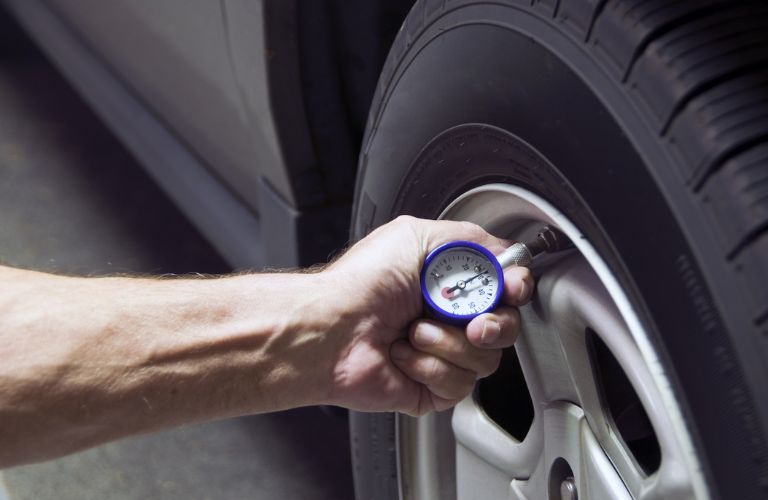 Hand of a man checking tire pressure