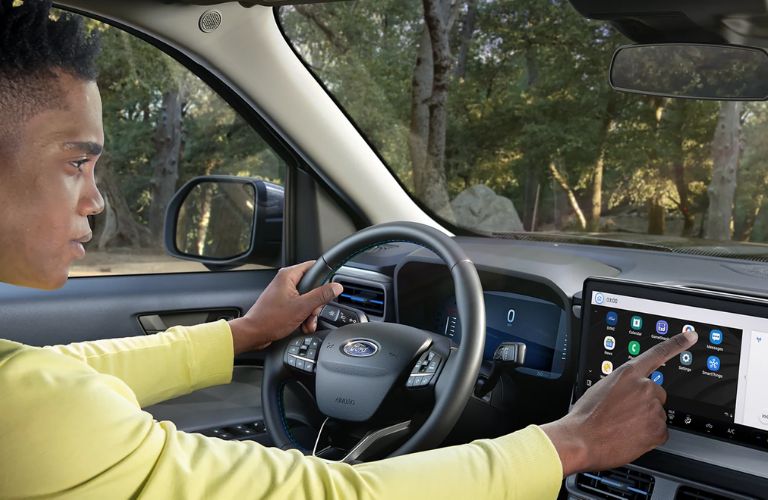 A woman using the infotainment display of the 2025 Ford Maverick®