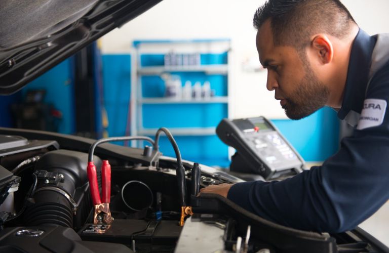 A mechanic inspecting a vehicle's battery