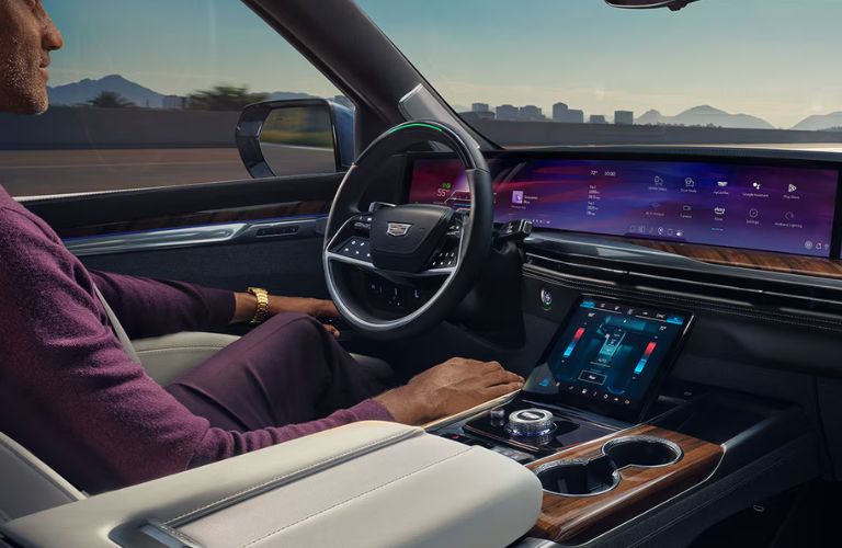 A man driving a Cadillac vehicle